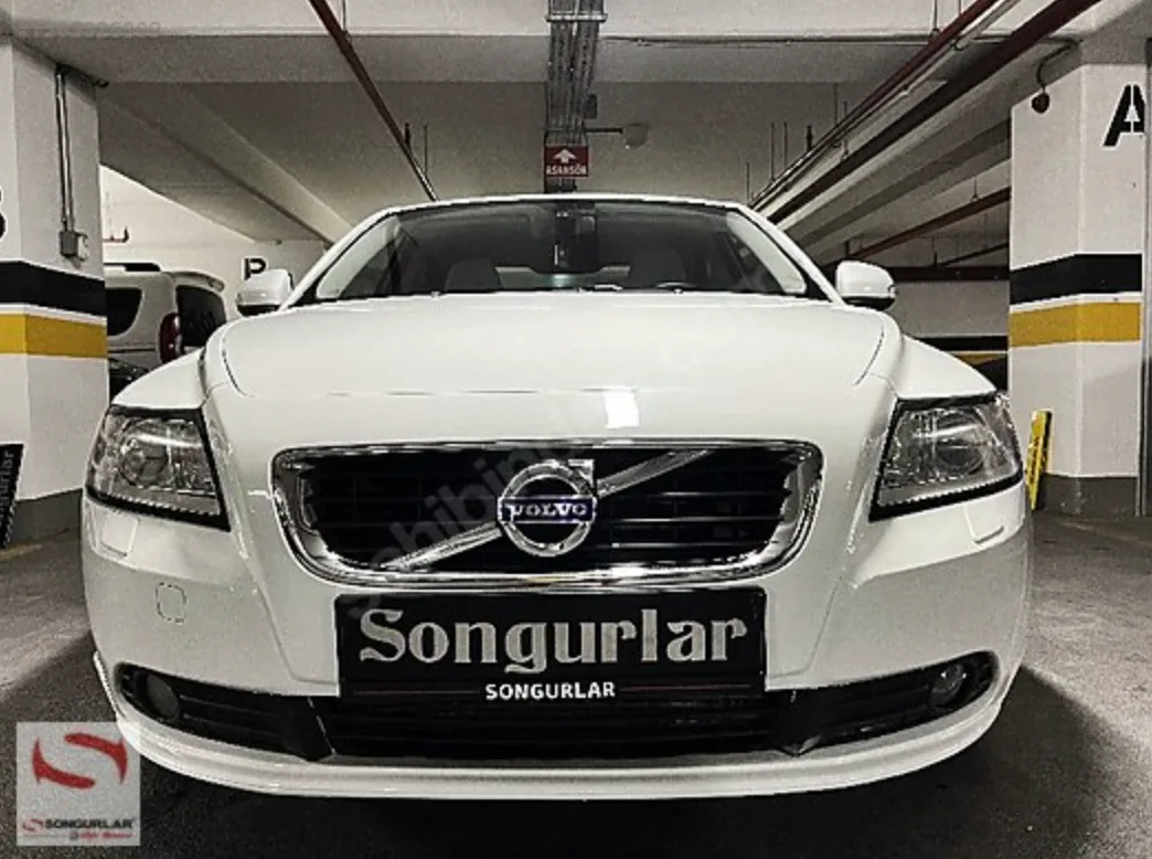 Beyaz Volvo sedan, önden görünüm